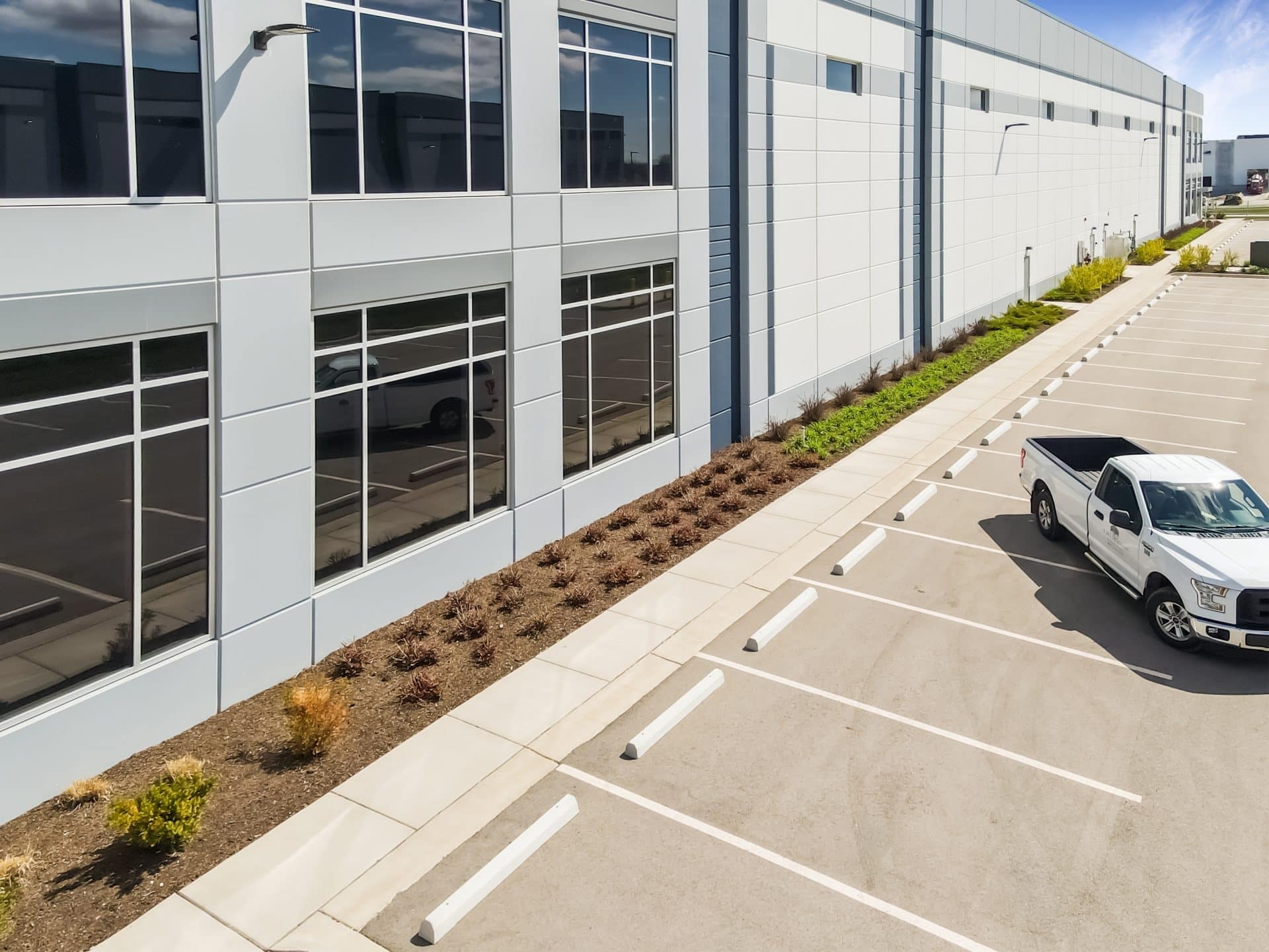 Commercial landscape maintenance crew mowing office park grounds by A.M. Woodland